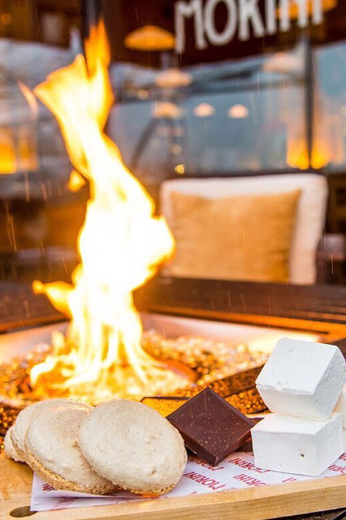 S'mores ingredients sitting by a fire pit during an event on the waterfront