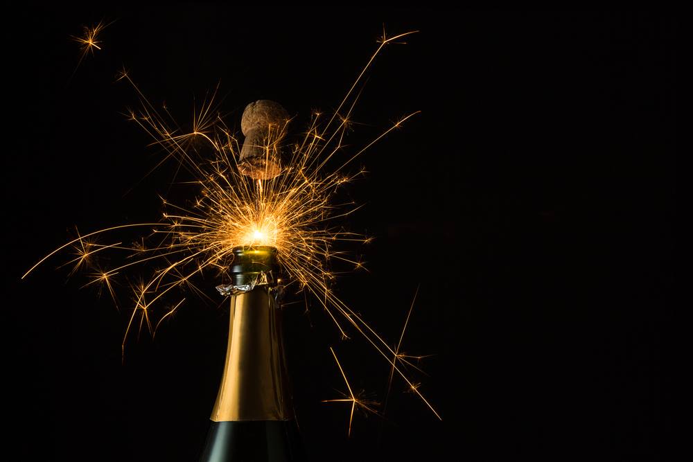 Fireworks popping the cork out of a champagne bottle
