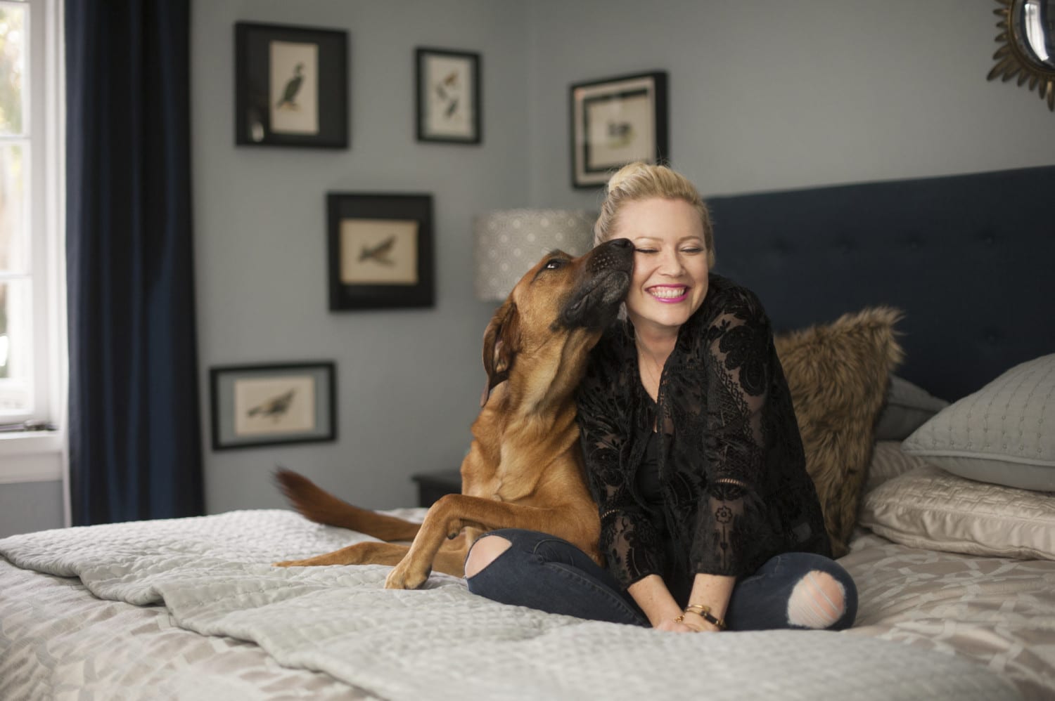 A woman and her dog on a bed