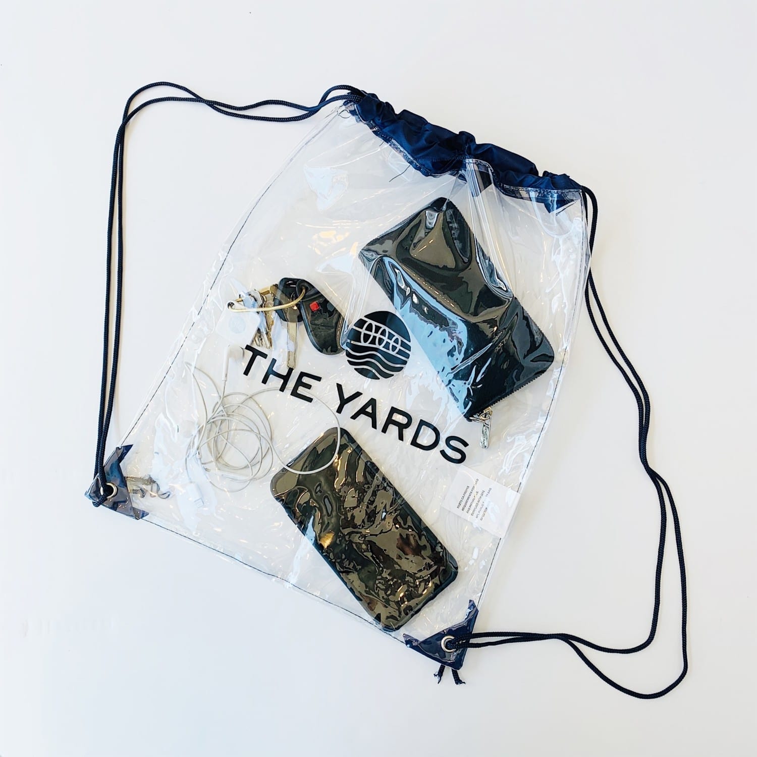 Plastic drawstring bag with the Yards DC logo containing phone, wallet, keys