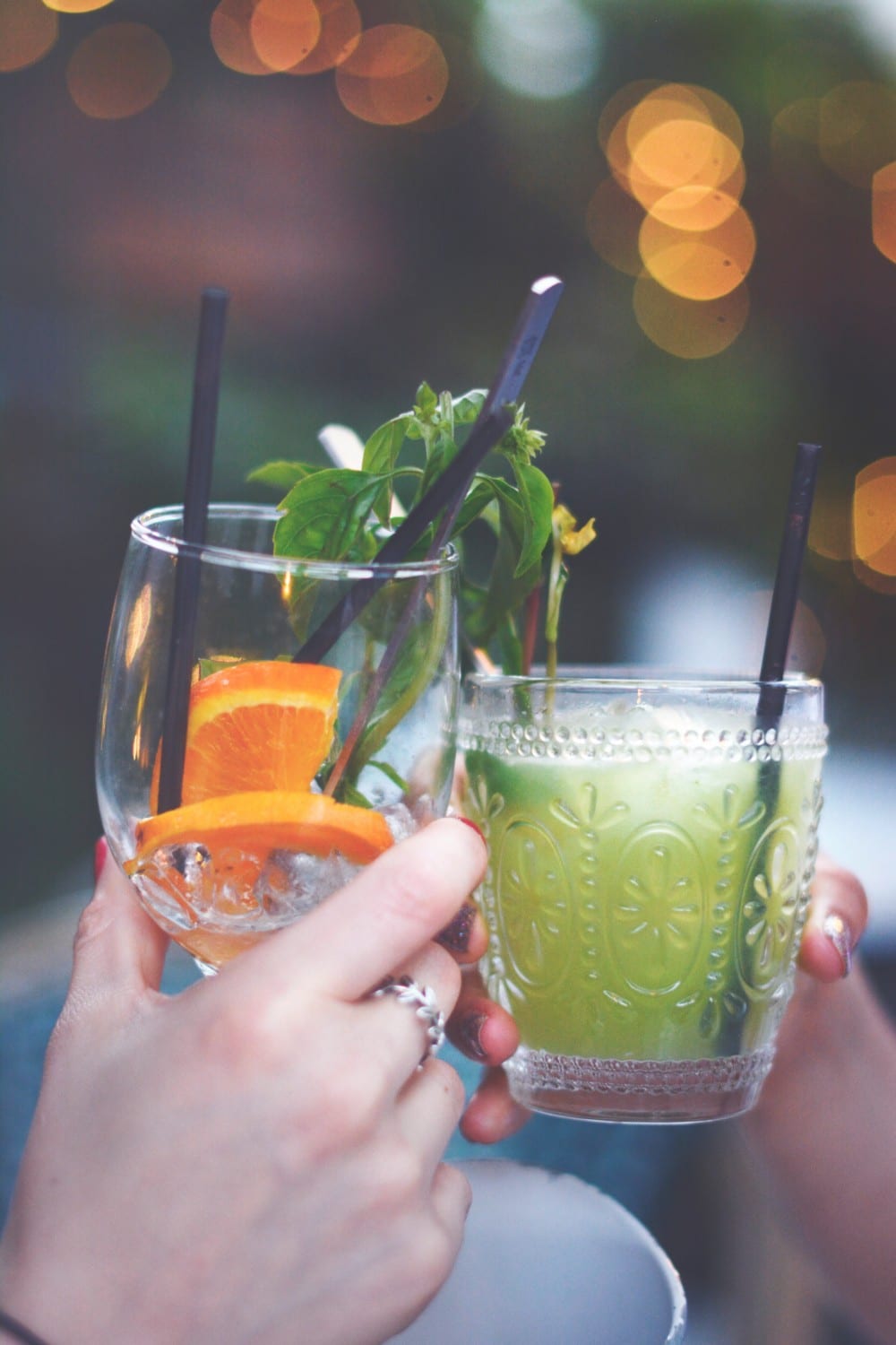 2 friends enjoy a toast of fruity drinks in the evening