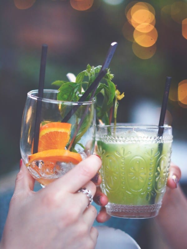 2 friends enjoy a toast of fruity drinks in the evening